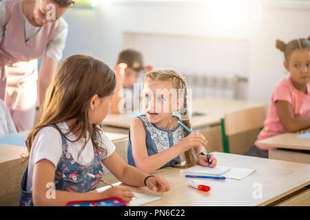 A scuola i bambini partecipano attivamente in classe. Istruzione, compiti concept Foto Stock