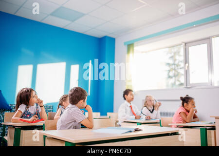 I bambini delle scuole che partecipano attivamente al lavoro di classe. Istruzione, apprendimento di alta scuola Foto Stock