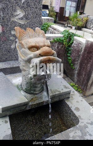 Stone testa di drago sgorga acqua sorgiva calda per i visitatori, Bessho Onsen, Prefettura di Nagano, Honshu, Giappone. N. PR Foto Stock