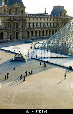 La piramide di vetro e turisti a piedi a Louvre, Parigi, Francia. Foto Stock