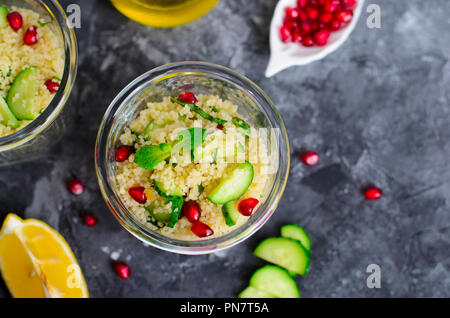 Il cous cous insalata in un vaso con melograno, menta e cetrioli, sano cibo fatto in casa, pasto vegano Foto Stock