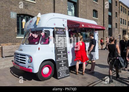 Una giovane coppia comprare un gelato dal violetto Ruby's ice cream van nel granaio Square, Kings Cross, Camden, London, N1, Regno Unito Foto Stock