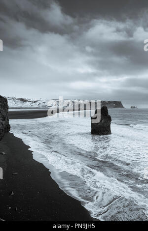 Reynisdrangar basalto pile di mare (troll rocce) e sabbia nera vulcanica spiaggia Reynisfjara vicino al villaggio V'k i Myrdal, Sud Islanda Foto Stock