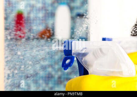 Persona che fa faccende in bagno a casa lo specchio di pulizia con detergente spray Foto Stock