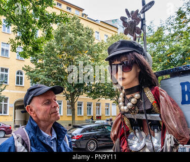 Berlino, Prenzlauerberg. Foto Design Studio Hartmut Li, Senior uomo anziano guardando bizzarro manichino al di fuori del negozio fotografico Foto Stock