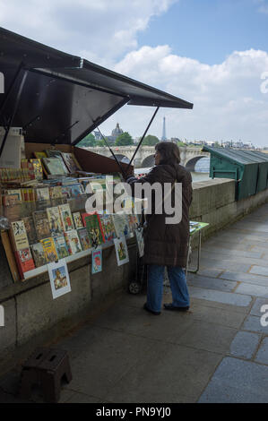 Parigi, Francia, Maggio 2013 : libro di stallo venditore accanto al fiume Senna con la torre Eiffel sullo sfondo. Foto Stock