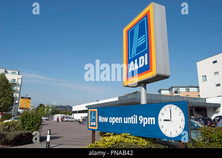 Firmare con il nome e il logo di Aldi, ad un ramo della catena di supermercati in Hounslow, Middlesex, Inghilterra, con ulteriore sospiro affermando ora aperta fino alle 9 di sera Foto Stock