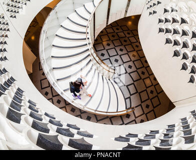 Vista dal di sopra della donna che cammina verso il basso una scalinata a spirale alla Tate Modern di Londra Foto Stock