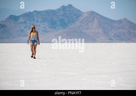 Una donna bionda passeggiate attraverso Bonneville Saline, Tooele County, Utah, Stati Uniti d'America. Foto Stock