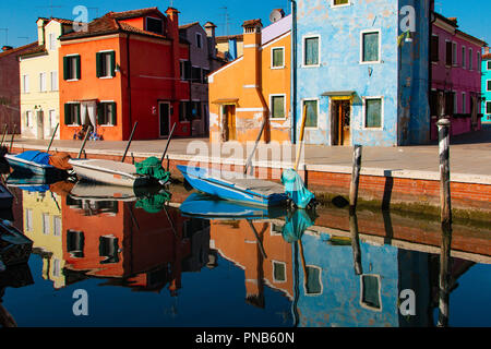 Case colorate lungo un canale di Burano con una bella riflessione in acqua Foto Stock