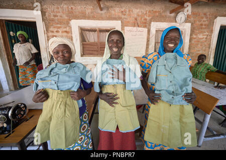 Le donne visto orgogliosamente visualizzazione uniformi di scuola dopo la cucitura di loro presso la chiesa-run centro per le donne a Gidel. Un villaggio nella regione dei monti Nuba del Sudan che viene controllata mediante la liberazione del popolo sudanese Movement-North ed è spesso attaccati dai militari del Sudan. Foto Stock