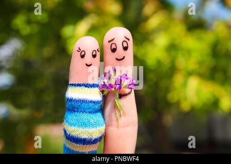 Arte del dito di una coppia felice. L uomo è dare fiori donna incinta. Foto Stock