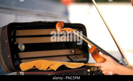 Le mani mettere il violino nel caso Foto Stock