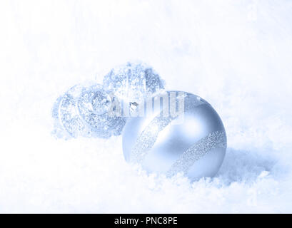 Luce blu Ornamenti natale in un letto di bianco della neve Foto Stock