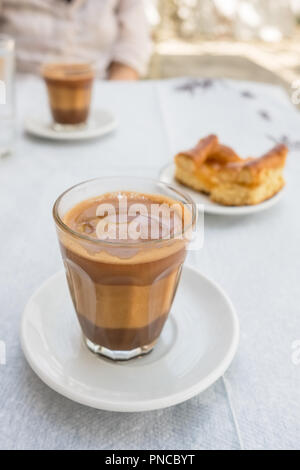 Caffè tradizionale greco servito con un pezzo di torta in outdoor cafe in Grecia Foto Stock