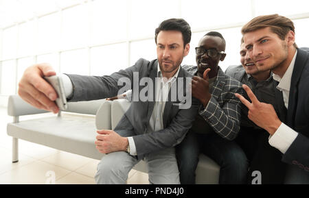 Team aziendale prende selfies nella lobby del centro business Foto Stock