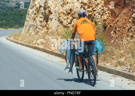 Butrinto, Albania- 29 giugno 2014: pesce pescato sono portati da un uomo su una bicicletta. Foto Stock