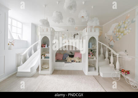 Interno di una spaziosa sala per bambini. Il castello di decorativo con letto interno, gioco slitta e scale Foto Stock