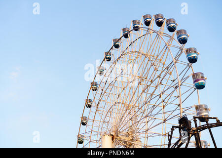 Alta rullo ruota panoramica Ferris con cielo blu come sfondo Foto Stock