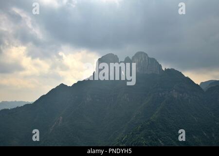 Il paesaggio collinare nella provincia del Hunan in Cina, la patria della minoranza etnica Miao. Maestosa struttura di roccia sulla sommità della collina. Foto Stock