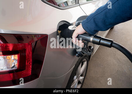 Primo piano dell'uomo il pompaggio gasolio per motori diesel in auto alla stazione di gas. Foto Stock