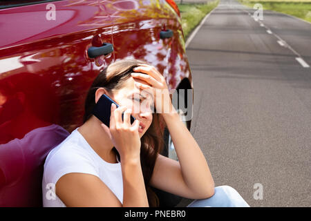 Ha sottolineato la donna in cerca di assistenza su cellulare dopo la ripartizione per auto Foto Stock