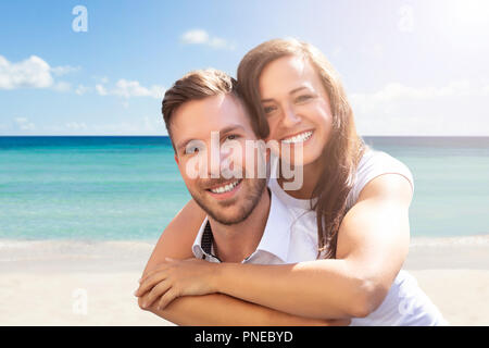 Ritratto di una felice coppia giovane per divertirsi in spiaggia Foto Stock