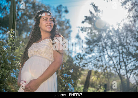 Bella donna incinta nel giardino. Foto Stock