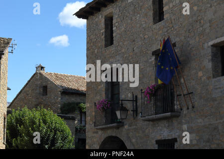 La pietra fece municipio con il Parlamento, Spagnolo e bandiere Aragonese nel medievale cittadina rurale Ainsa, situato nei Pirenei spagnoli montagne Foto Stock