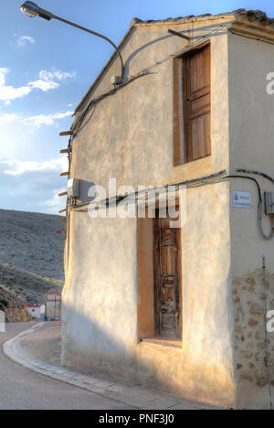 Un restaurato a due facciate porta marrone in un bianco e pareti beige con alcuni cavi che passa su di essa nel Almonacid de la Cuba paese rurale città in Spagna Foto Stock