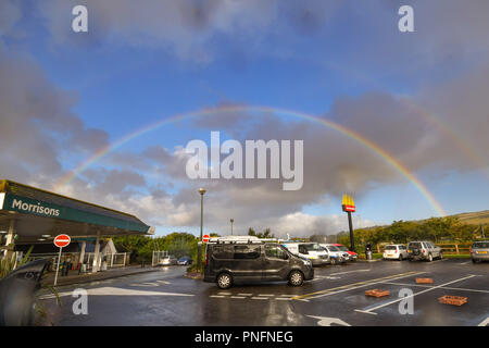 Rainbow formazione su McDonalds parcheggio auto e segno e Morrisons al momento della colazione Foto Stock