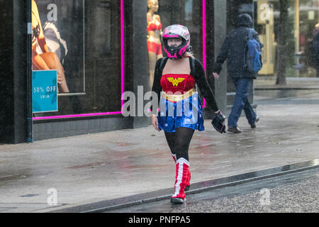 Donna che indossa il costume da adolescente Classic Supergirl (Wonderwoman) a Preston, Lancashire. Settembre 2018. UK Meteo: Docce pesanti e blustery nel centro della città. Credit; MediaWorldImages/AlamyLiveNews Foto Stock