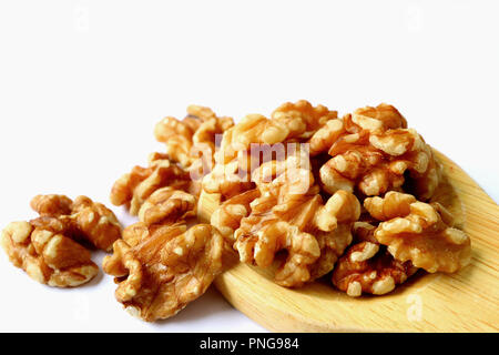 Chiuso fino mucchio di noci sul cucchiaio di legno isolato su sfondo bianco con il fuoco selettivo Foto Stock