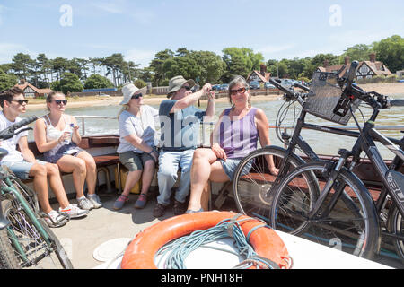 Gente seduta sul fiume Deben piedi passeggero traghetto a Bawdsey Quay, Suffolk, Inghilterra, Regno Unito Foto Stock