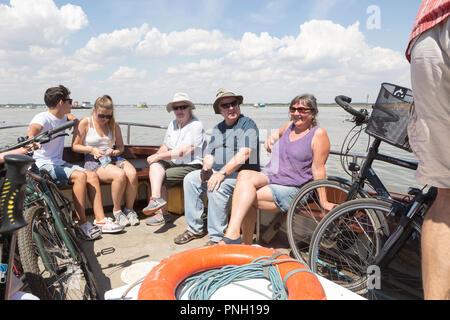 Gente seduta sul fiume Deben piedi passeggero traghetto a Bawdsey Quay, Suffolk, Inghilterra, Regno Unito Foto Stock