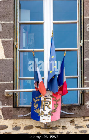 Bandiera europea e la bandiera francese sul municipio facciata in un villaggio, Puy de Dome, Auvergne Rhone Alpes, Francia Foto Stock