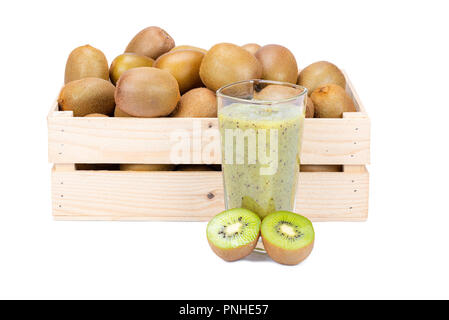 Scatola di legno con maturi kiwi e con un bicchiere di fresco Frullato di kiwi isolati su sfondo bianco Foto Stock