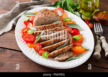 Gustosi piatti fatti in casa al forno di terra la Turchia polpettone in piastra bianca sul tavolo di legno. Cibo american pagnotta di carne. Foto Stock