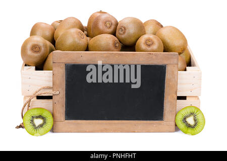 Scatola di legno riempita con molti mature kiwi e due metà di frutta e una vecchia ardesia vuoto blackboard isolati su sfondo bianco Foto Stock