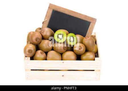 Scatola di legno riempita con molti mature kiwi e due metà di frutta e una vecchia ardesia vuoto blackboard isolati su sfondo bianco Foto Stock