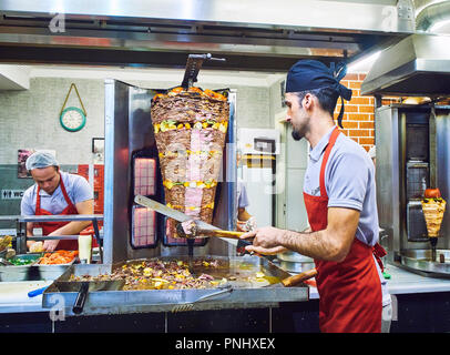 Bodrum, Turchia - Luglio 5, 2018. Un cuoco il taglio di carne e verdure fette di un tradizionale bagno turco Döner Kebab in una bancarella di strada. Foto Stock