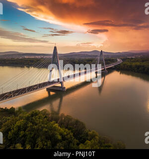 Budapest, Ungheria - Ponte Megyeri oltre il Fiume Danubio al tramonto con belle nuvole drammatico e cielo Foto Stock