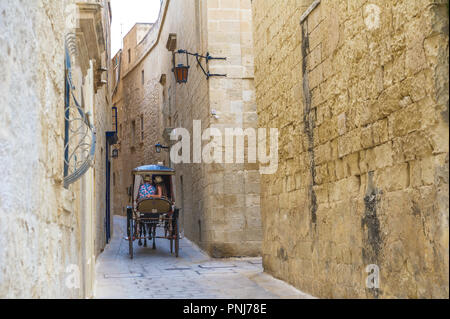 Carrozza a cavalli (karozzin) negoziare gli stretti vicoli di Mdina, Malta. Foto Stock