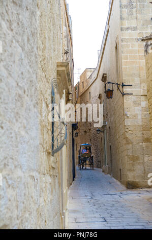 Carrozza a cavalli (karozzin) negoziare gli stretti vicoli di Mdina, Malta. Foto Stock