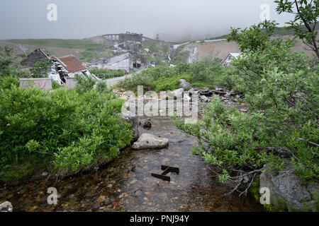 Vecchio arrugginito abbandonato gli strumenti di data mining e di attrezzature di indipendenza miniera Alaska lungo Hatcher Pass. Moody nebbia dà una sensazione da brivido Foto Stock