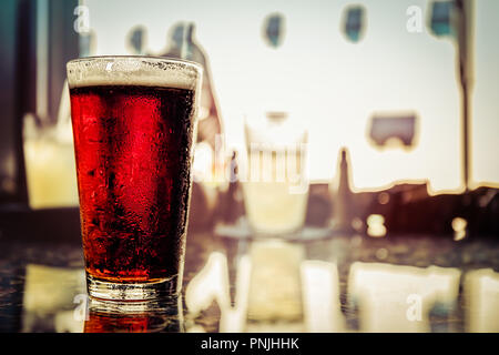 Una pinta di birra fredda di Irish Ale si siede sulla parte superiore di una tavola. Foto Stock