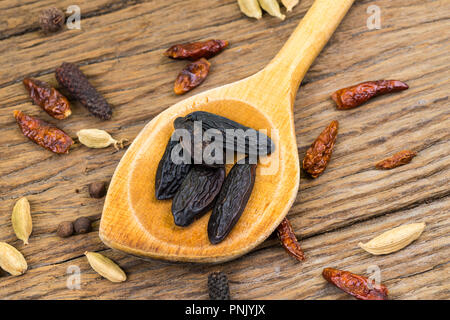 Primo piano della intera fave tonka su un vecchio legno cucchiaio di legno su legno rustico sfondo con spazio di copia Foto Stock