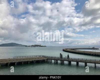 Moli sulla Baia di San Francisco con vista dell'Isola di Alcatraz, presi dal Fisherman's Wharf Foto Stock
