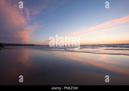 Tramonto riflesso in un mare calmo a cappella Porth Beach, vicino a St Agnes, Cornwall, Regno Unito, Settembre Foto Stock