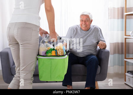 Padre guardando la sua figlia Azienda Negozi di generi alimentari nel carrello Foto Stock
